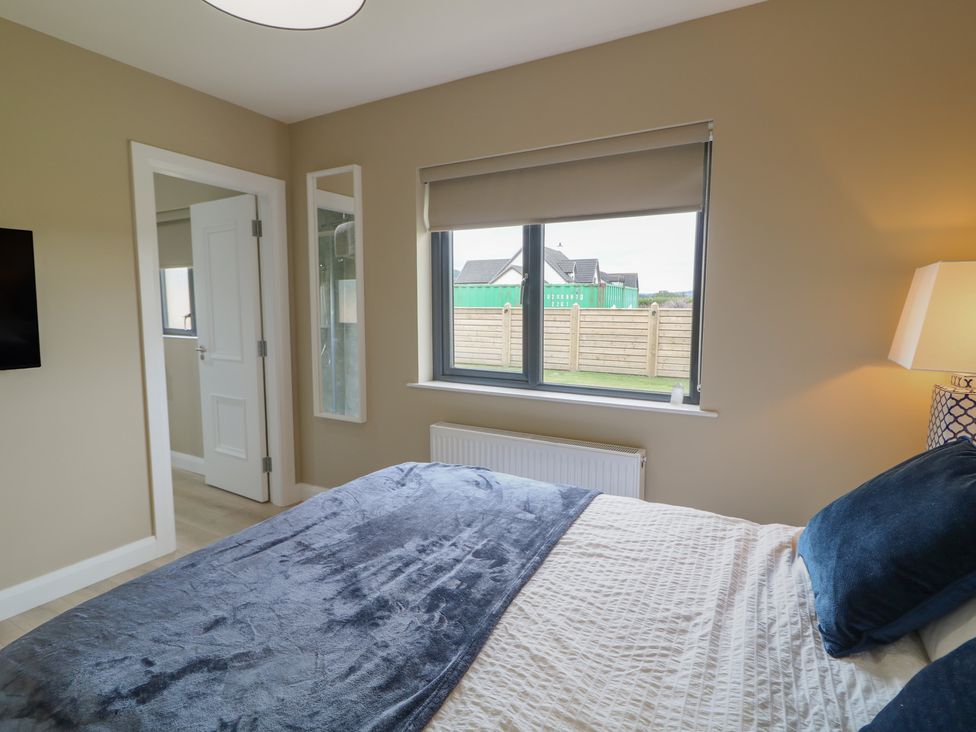 A bedroom with a bed and window at Clarmes House in Limavady