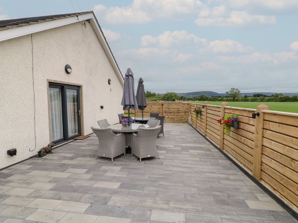 An outdoor patio with table and chairs at Clarmes House in Limavady
