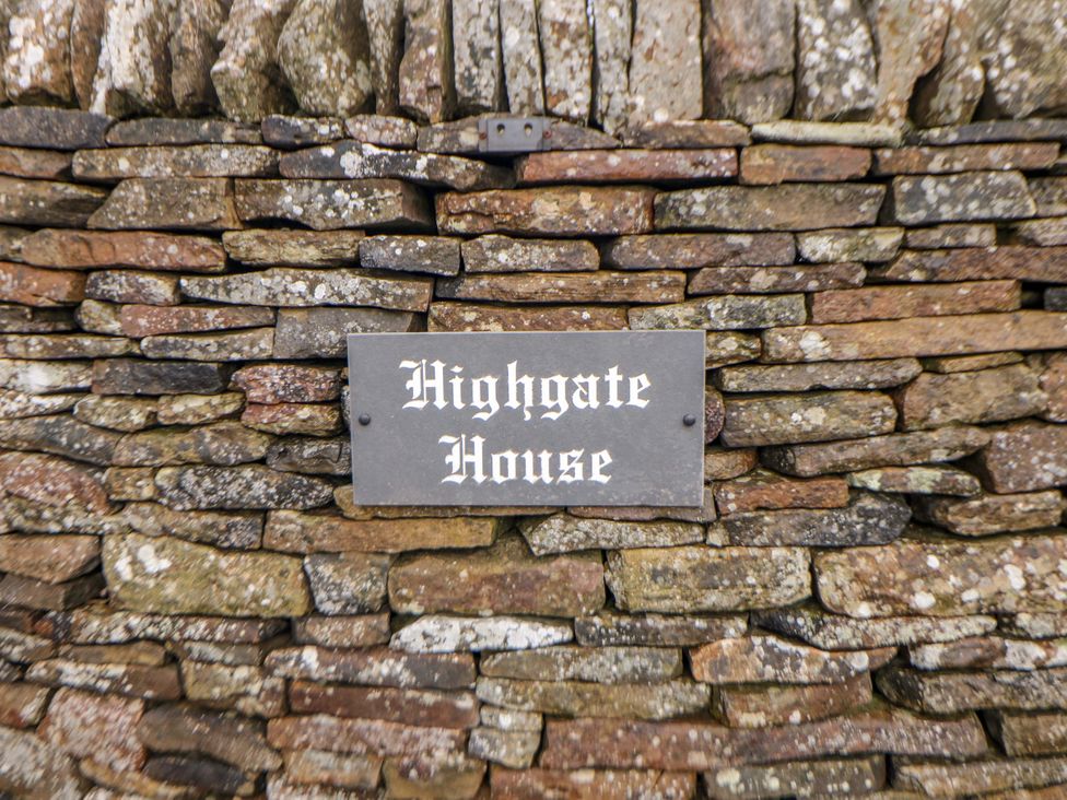 A stone wall with a nameplate reading Highgate House