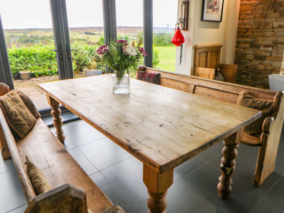A dining room with a wooden table and benches at Highgate house