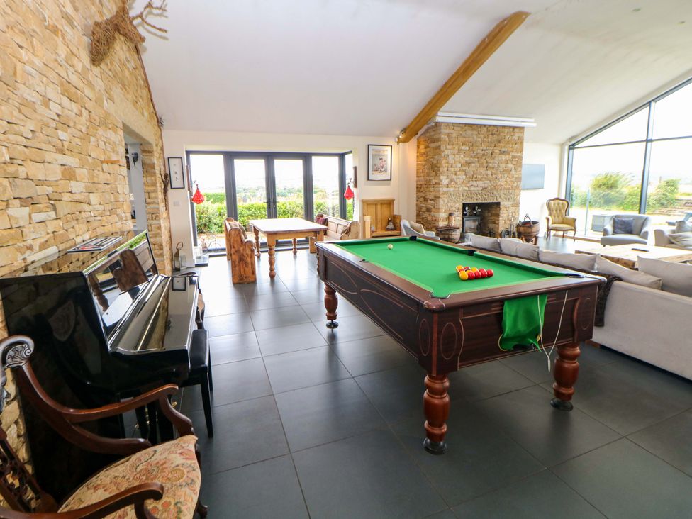 A living room with a pool table and piano at Highgate house