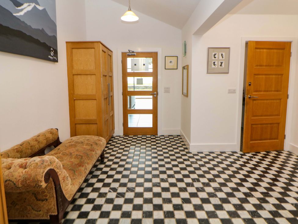 A hallway with a patterned floor and a sofa at Highgate house 