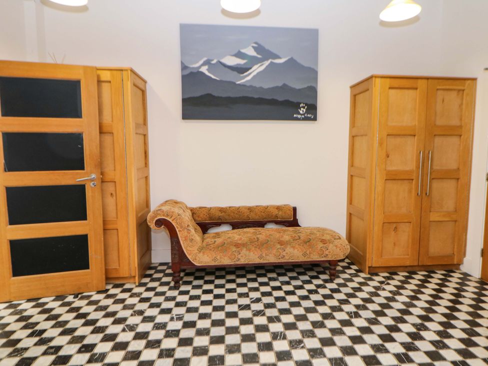 A hallway with a chaise longue and wardrobes at Highgate house