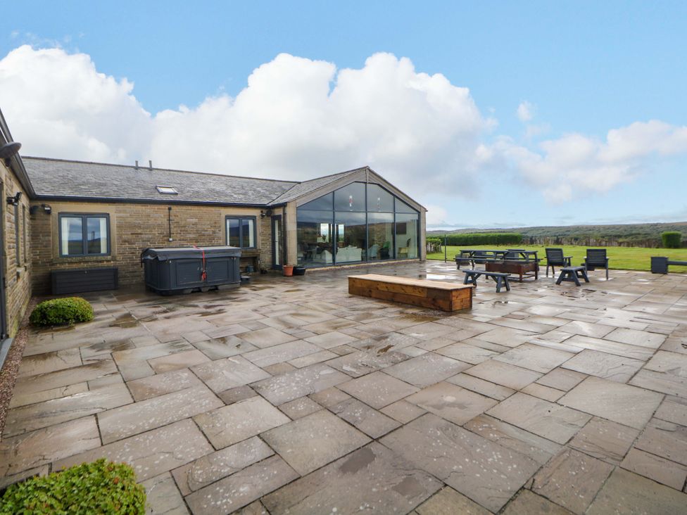 An outdoor area with a hot tub and seating at Highgate house