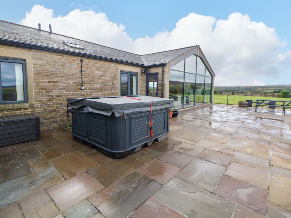 A patio with a hot tub and outdoor furniture at Highgate house