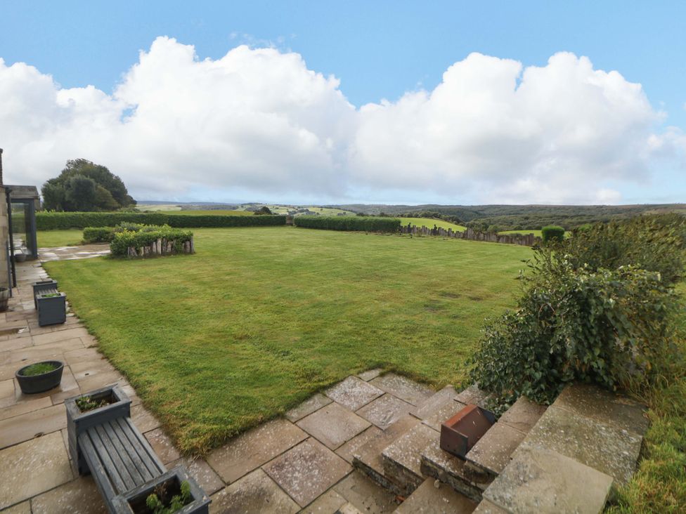 A garden with a lawn and stone patio at Highgate house