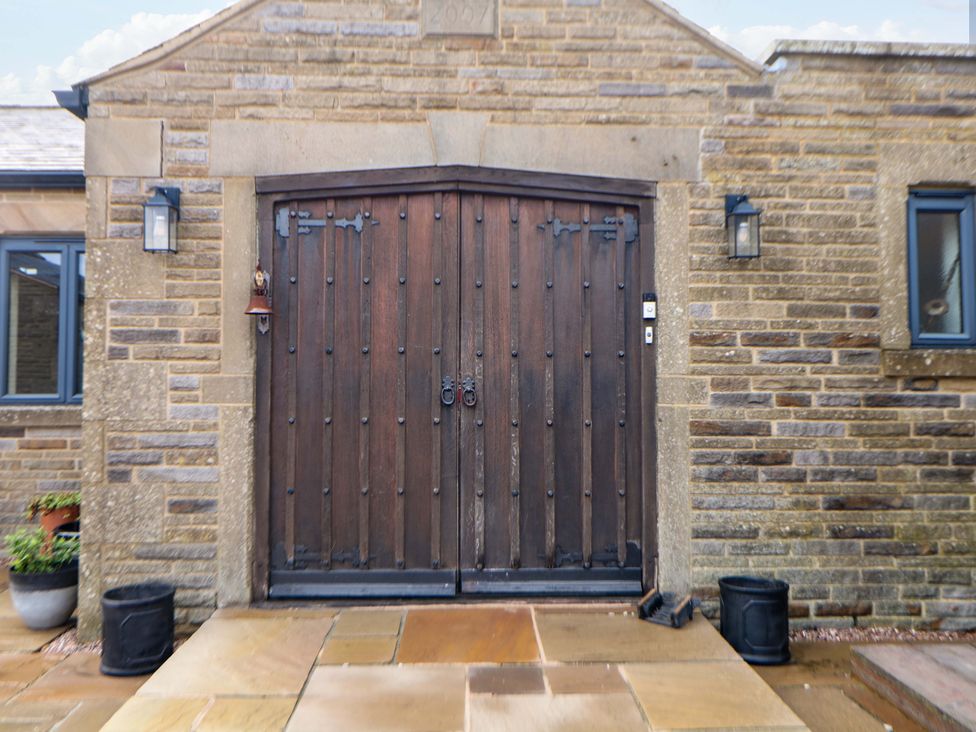 An entrance with wooden doors and stone walls at Highgate house Holmesfield near Dronfield