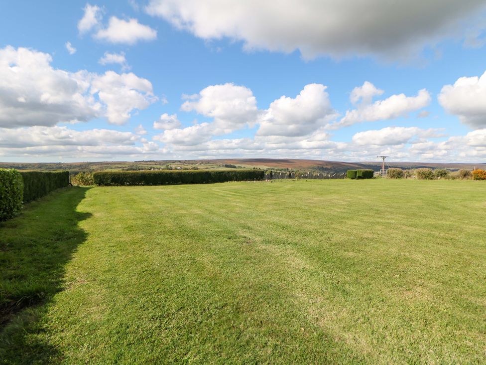 A landscape view with grass and a hedge at Highgate house in Holmesfield near Dronfield