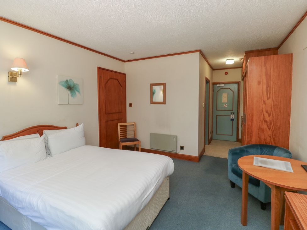 A bedroom with a bed, table and chair at Tor in Newton Abbot