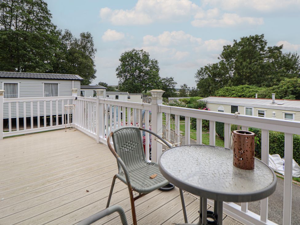 An outdoor patio with a table and chair at property 96 in Ruthin