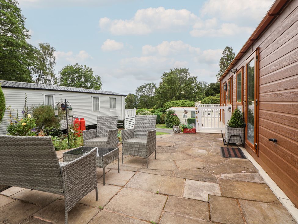 A patio area with chairs and greenery at 96 Ruthin