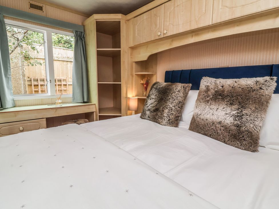 A bedroom with a bed and shelves at Big Bertha by the Sea, Northam