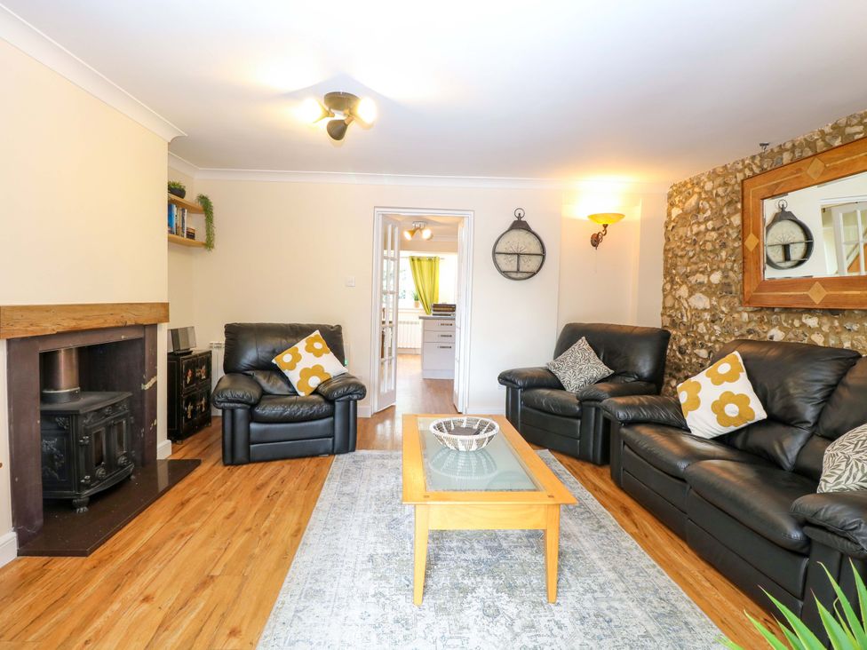 A living room with leather sofas and a coffee table at Honeysuckle Cottage in Swaffham