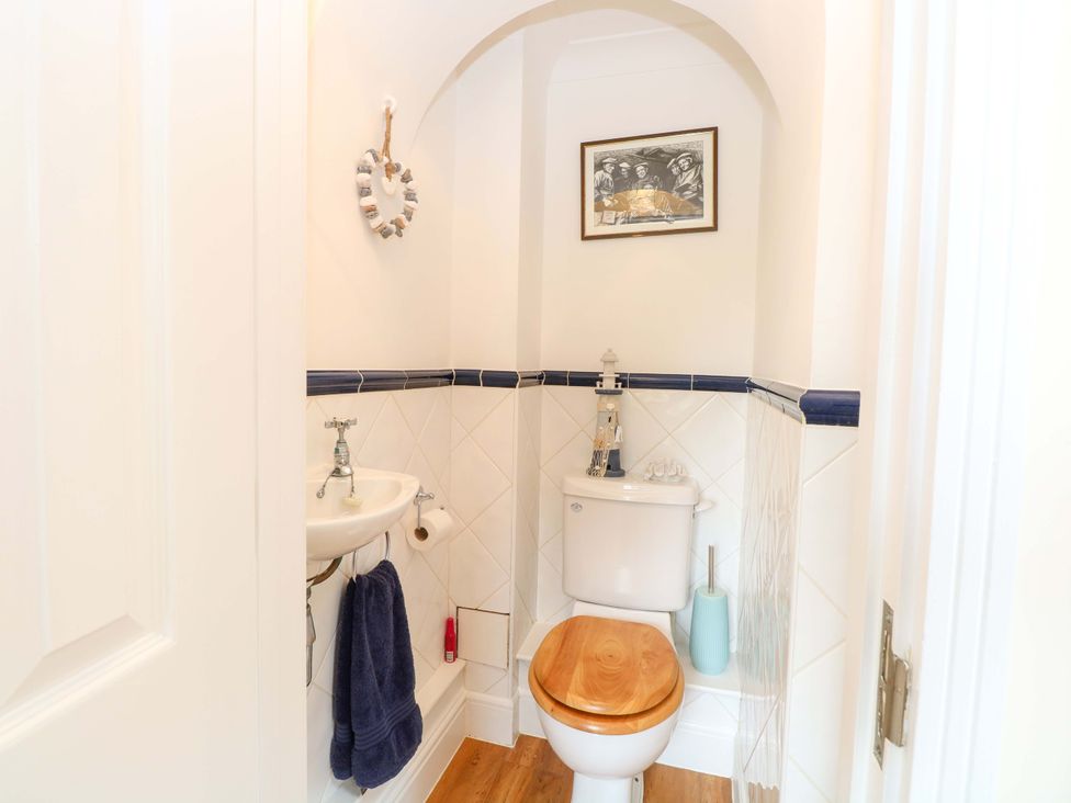 A bathroom with a toilet and sink at Honeysuckle Cottage in Swaffham