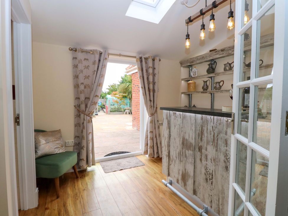 An entryway with a bar and shelves at Honeysuckle Cottage in Swaffham