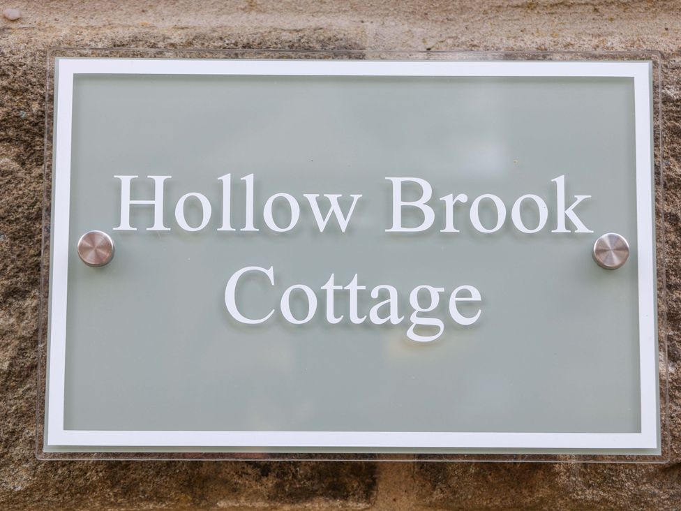 A sign displaying Hollow Brook Cottage in Hope Valley