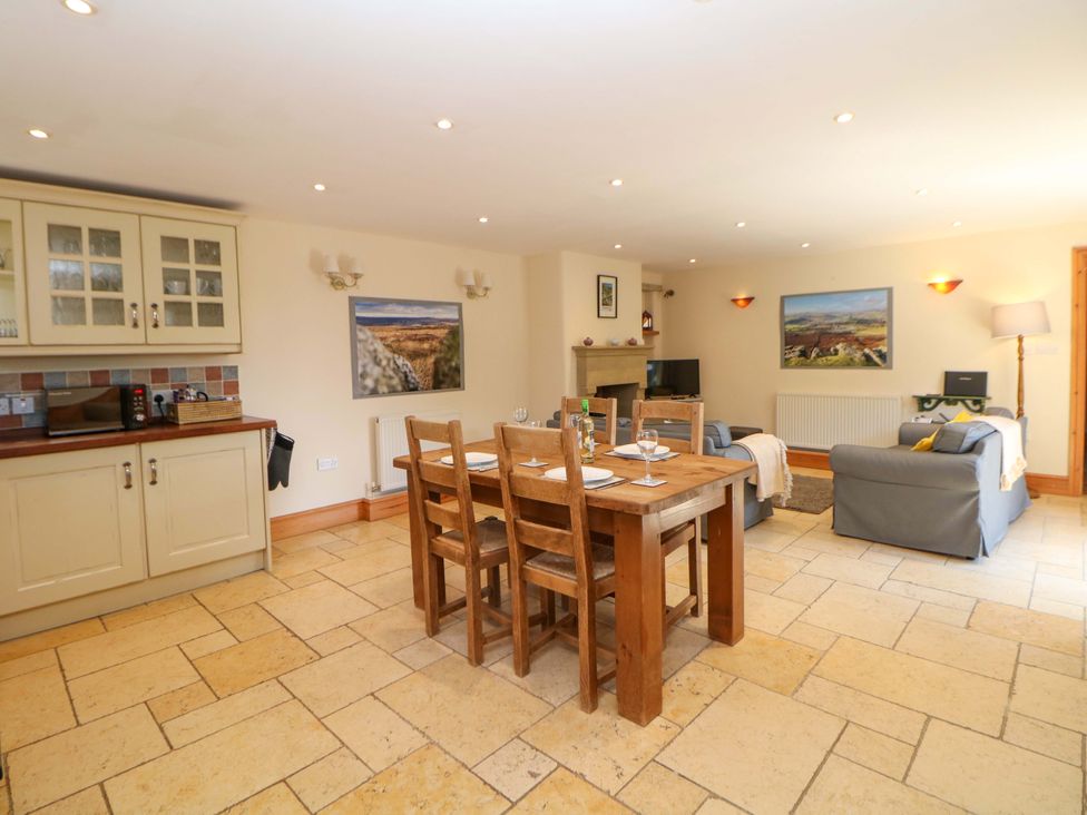 A living room with a dining table and chairs at Hollow Brook Cottage in Hope Valley