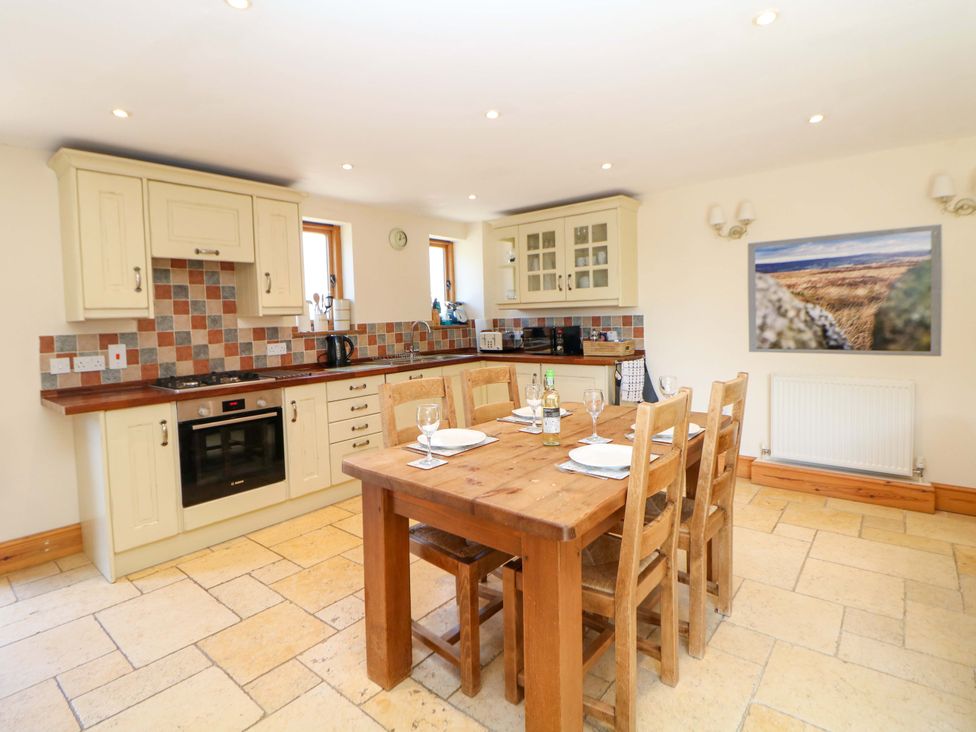 A kitchen with a dining table and chairs at Hollow Brook Cottage in Hope Valley