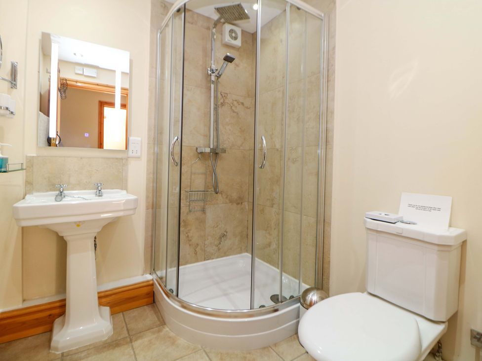 A bathroom with a shower, sink and toilet at Hollow Brook Cottage in Hope Valley