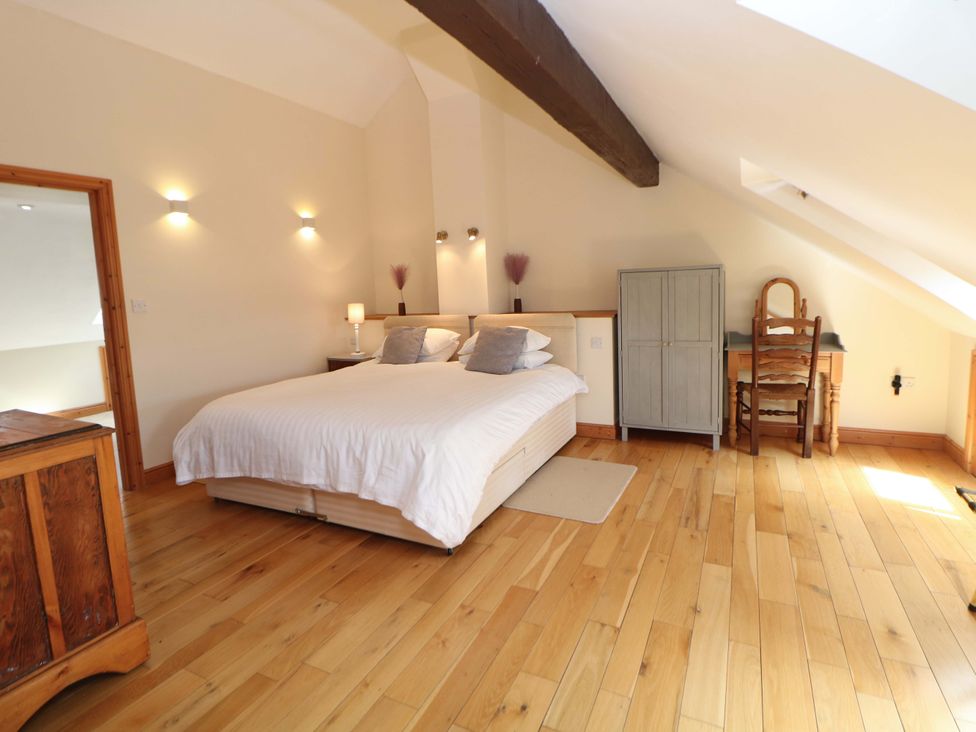 A bedroom with a bed, nightstand, and wardrobe at Hollow Brook Cottage in Hope Valley