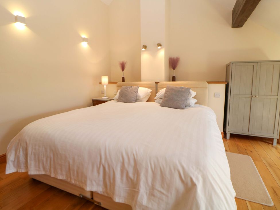A bedroom with a bed and wardrobe at Hollow Brook Cottage in Hope Valley