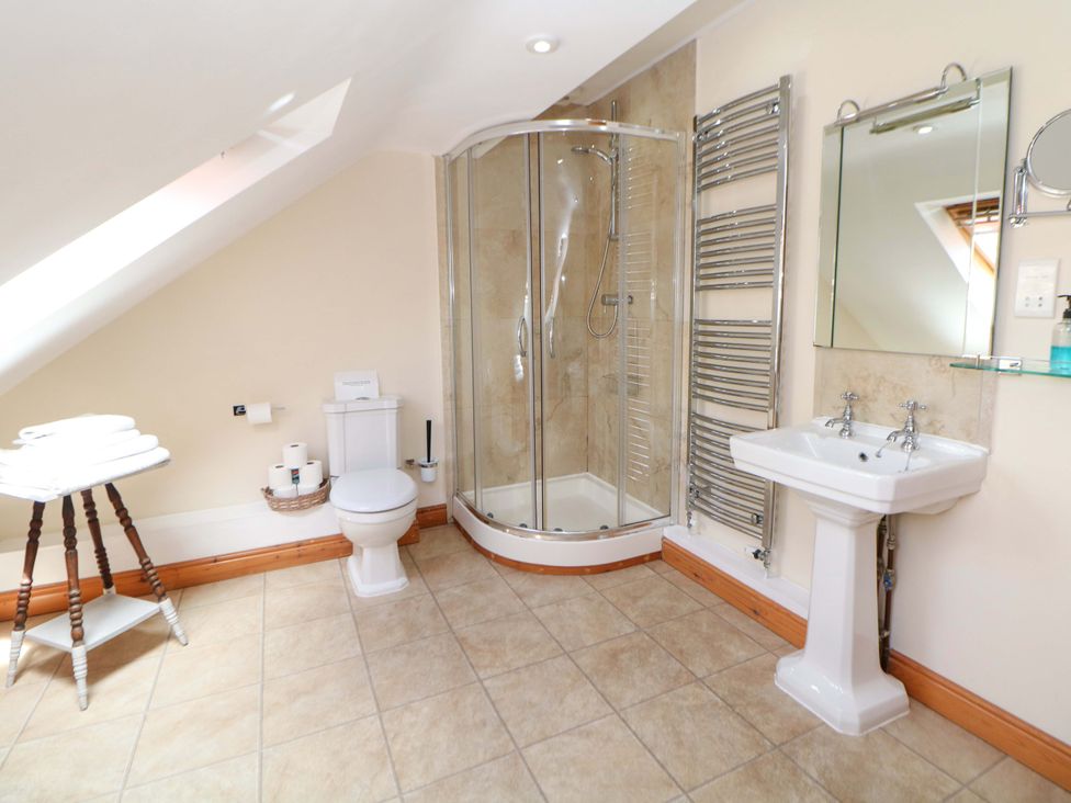 A bathroom with shower, toilet, and sink at Hollow Brook Cottage in Hope Valley