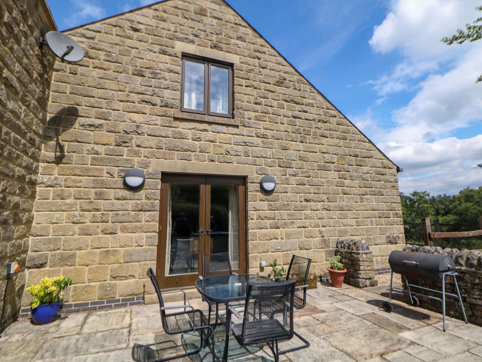 An outdoor seating area with a table and chairs at Hollow Brook Cottage in Hope Valley