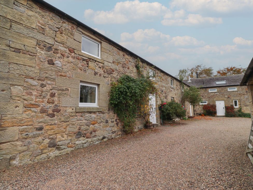 An outdoor view of stone buildings with plants at Honeymug in Branton near Powburn