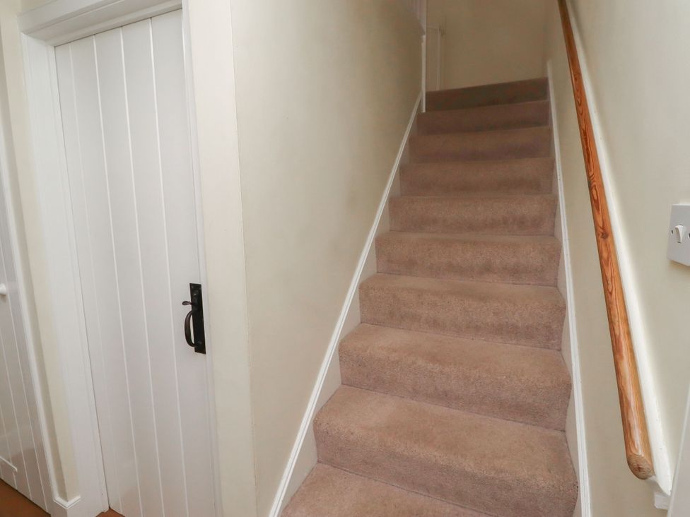 A staircase leading up with a door at the side at Honeymug in Branton near Powburn