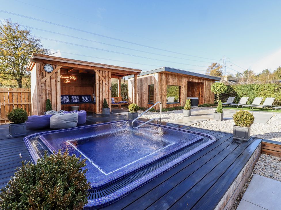 An outdoor area with a hot tub and wooden structures at Honeymug in Branton near Powburn