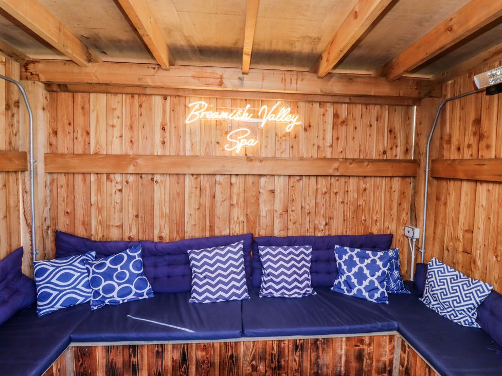 A snug with seating and a neon sign at Honeymug in Branton near Powburn