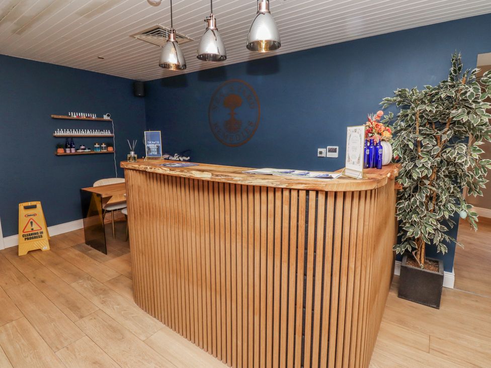 A reception area with a wooden desk and shelves at Honeymug in Branton near Powburn