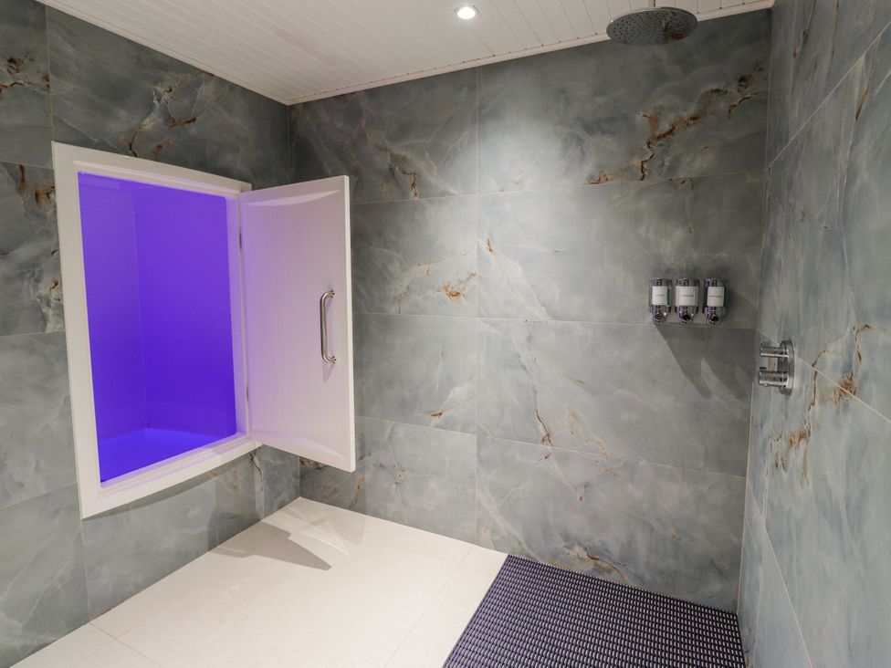 A bathroom with a shower and soap dispensers at Honeymug in Branton near Powburn
