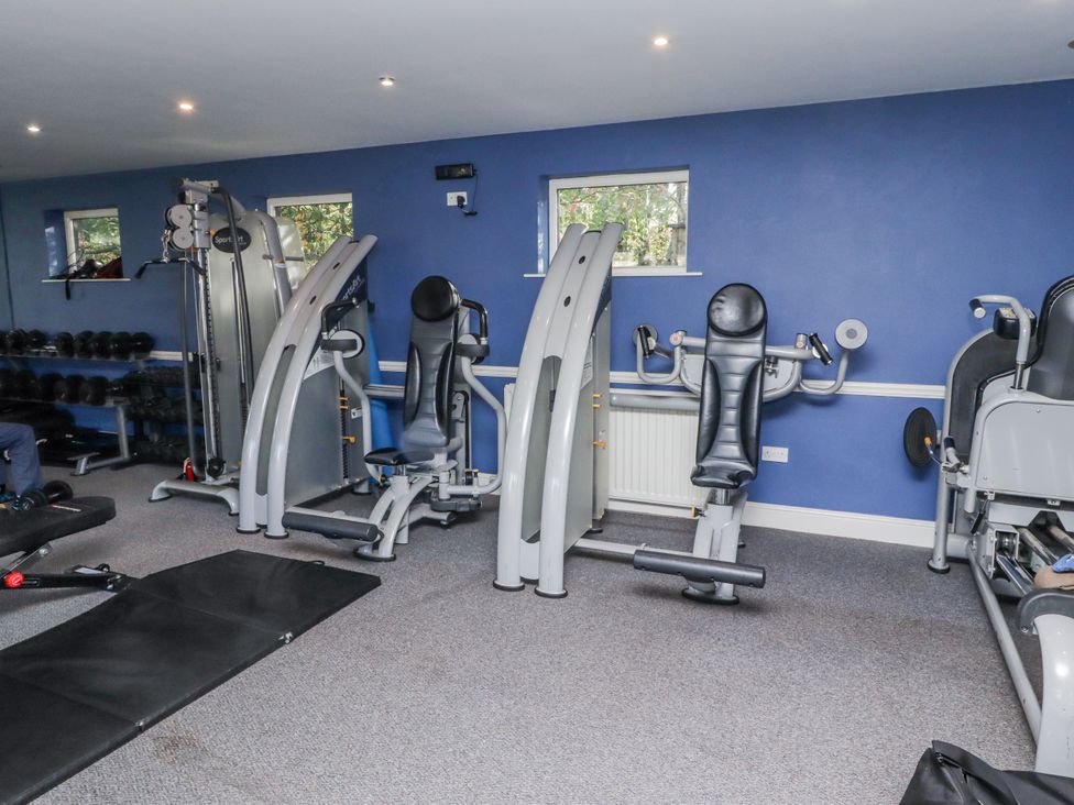 A gym with exercise machines and dumbbells at Honeymug in Branton near Powburn