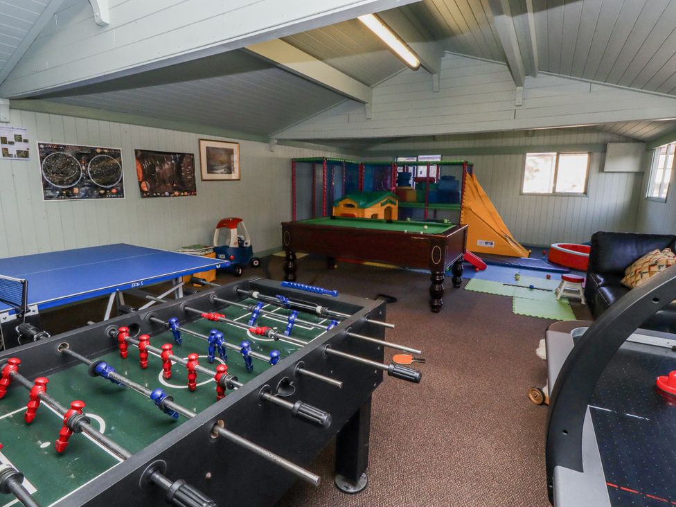 A playroom with a foosball table and a ping pong table at Honeymug in Branton near Powburn