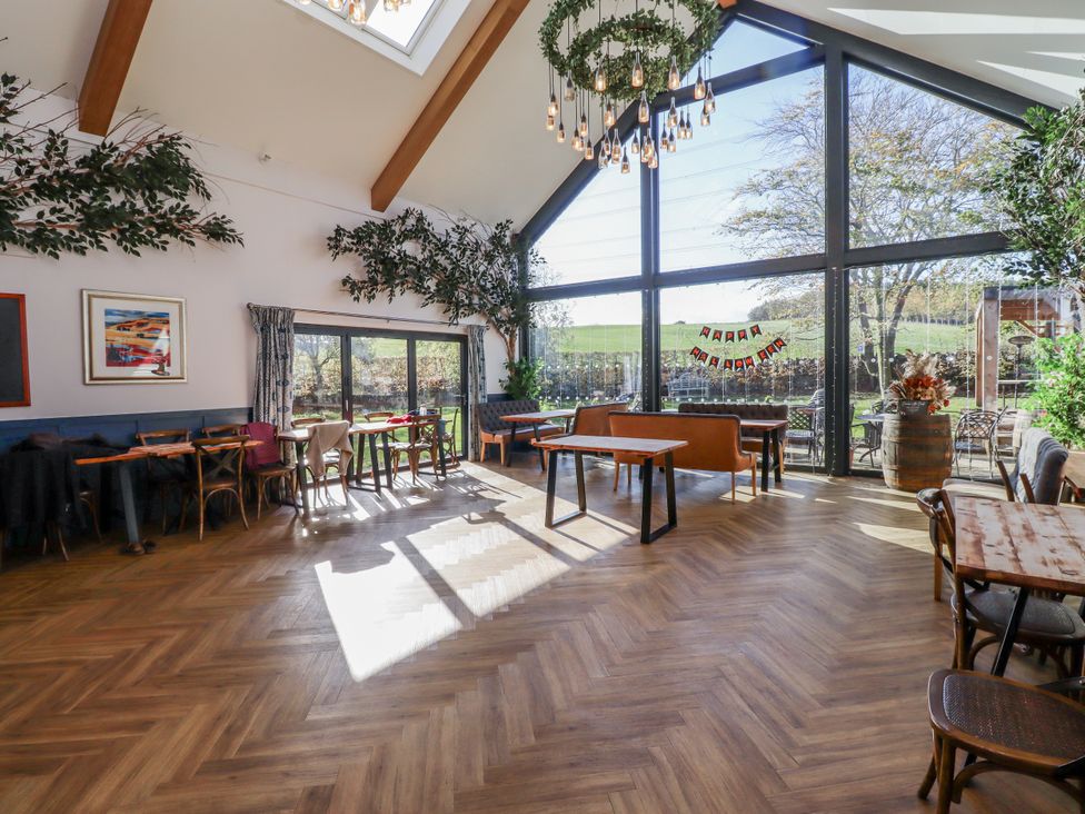 A dining room with tables and chairs at Honeymug in Branton near Powburn
