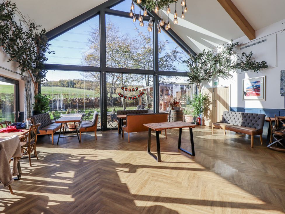A dining room with tables and chairs at Honeymug in Branton near Powburn