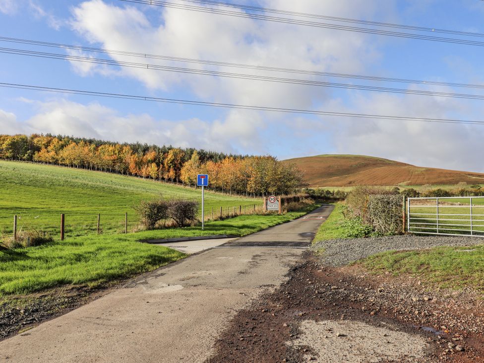 A road with a signpost and a gate at Honeymug in Branton near Powburn
