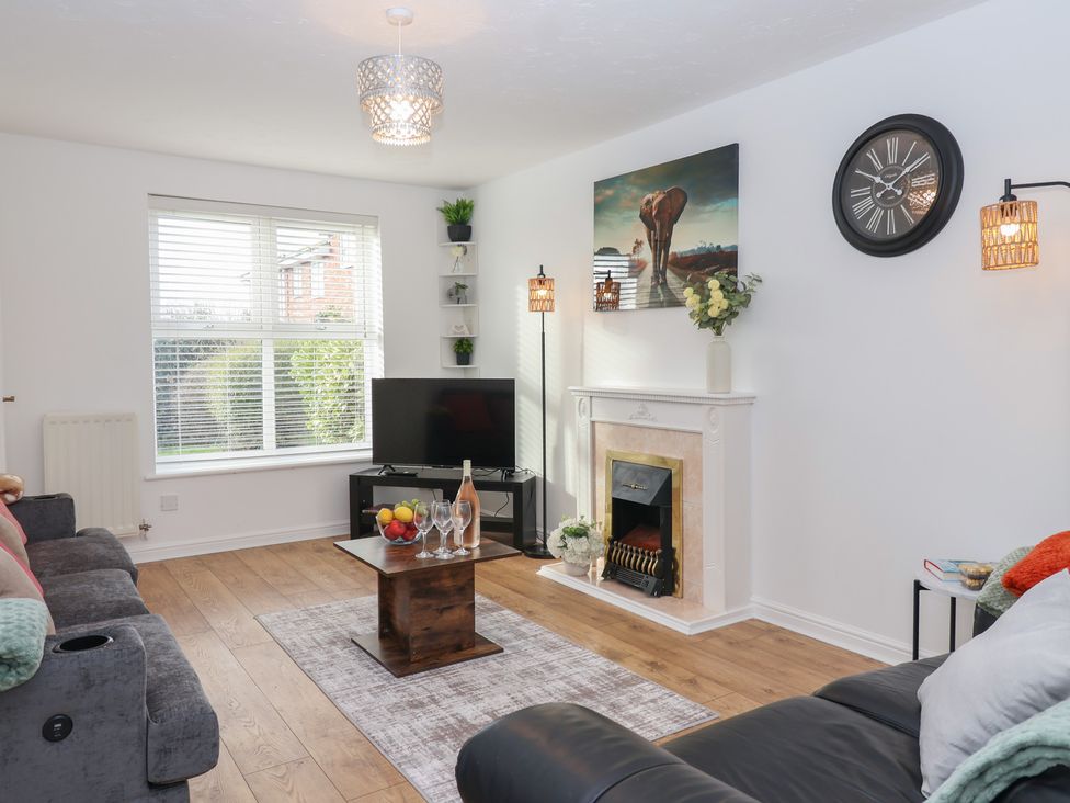 A living room with a sofa, coffee table, and television at The Cosy View in Paignton