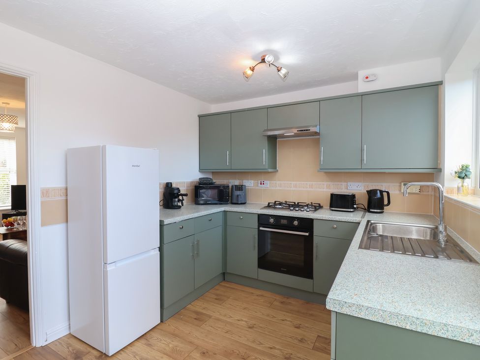 A kitchen with appliances including refrigerator and stove at The Cosy View in Paignton