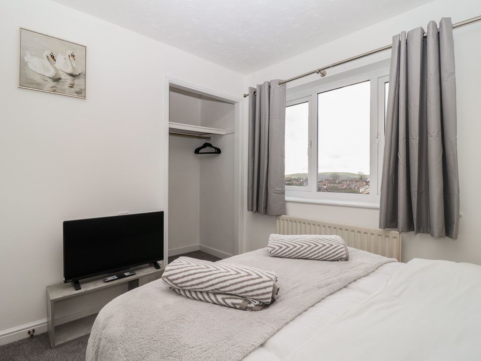 A bedroom with a bed, tv and wardrobe at The Cosy View in Paignton