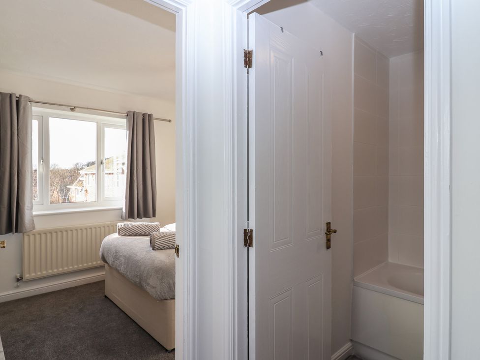 A bedroom with a bed and window at The Cosy View in Paignton