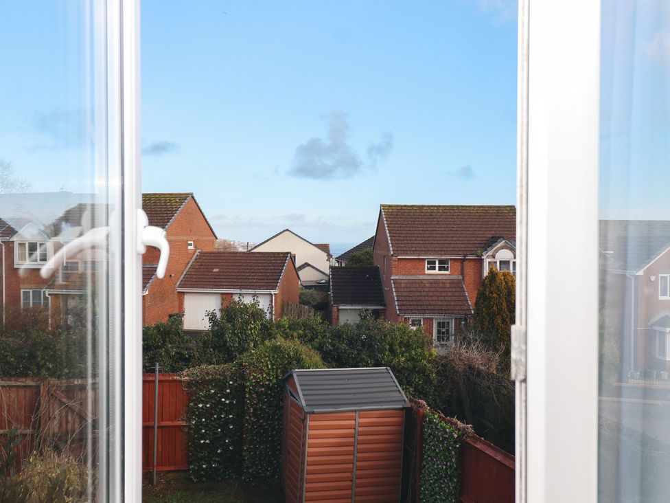 A view of houses and a garden shed from a window at The Cosy View in Paignton