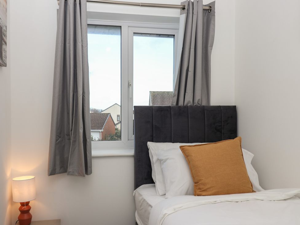 A bedroom with a bed and window at The Cosy View in Paignton
