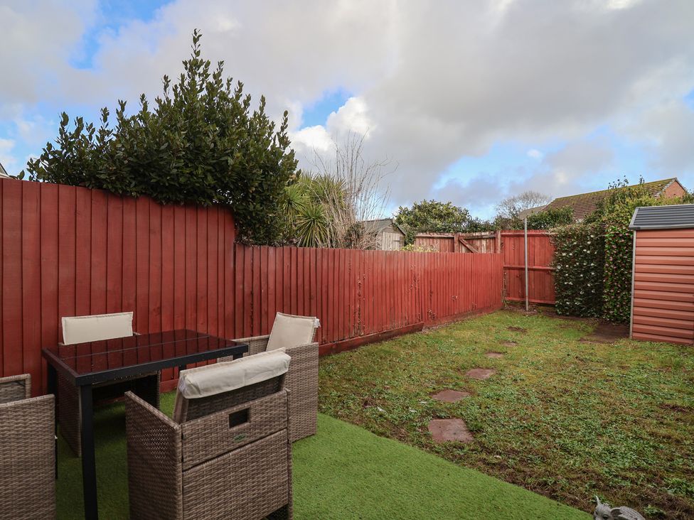 A garden with chairs and a table at The Cosy View in Paignton