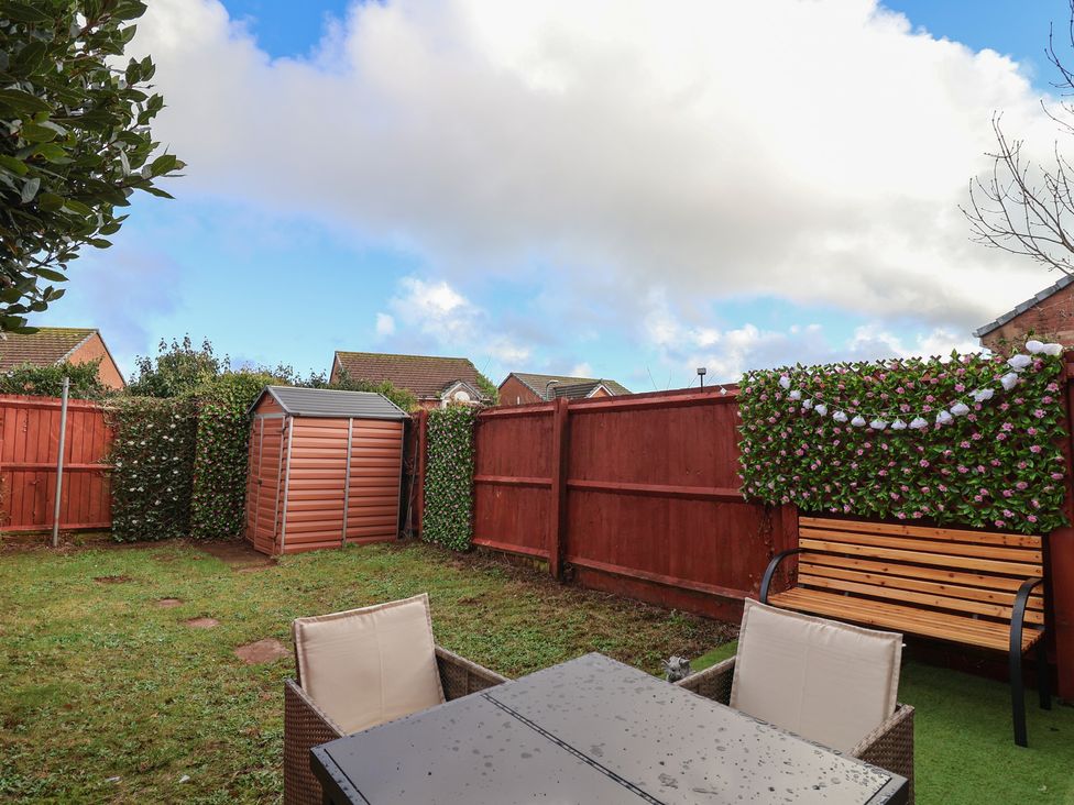A garden with a table and chairs at The Cosy View in Paignton