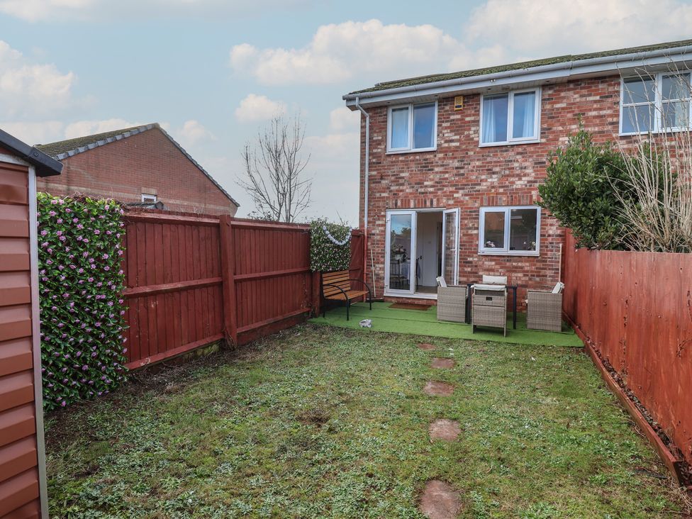 A garden with grass and furniture at The Cosy View in Paignton