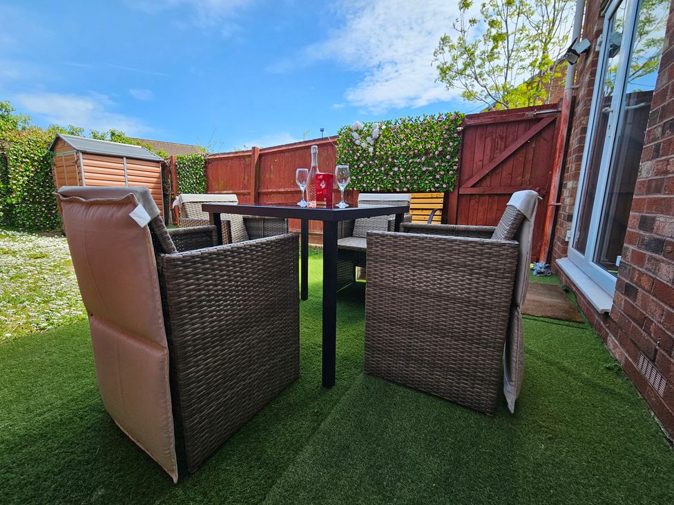 A garden with a table and chairs at The Cosy View in Paignton