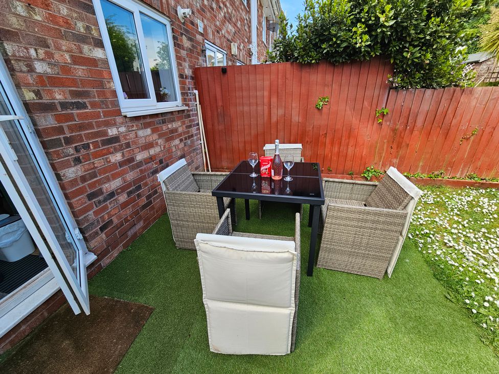 A garden with a table and chairs at The Cosy View in Paignton