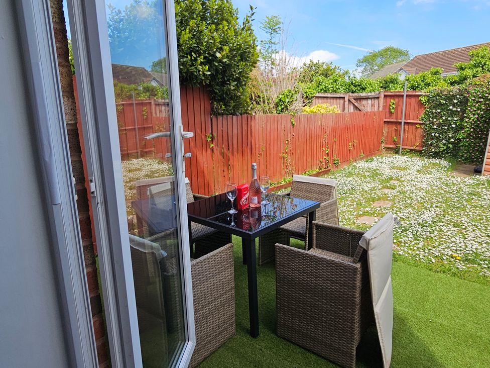A table with chairs in a garden at The Cosy View in Paignton